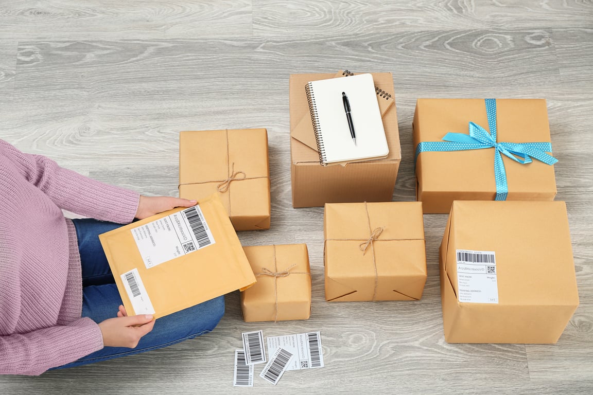 Woman Preparing Parcels for Shipment to Customer on Floor